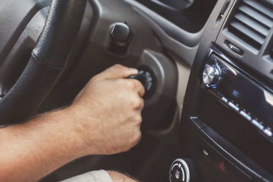 A hand turning the key in ignition