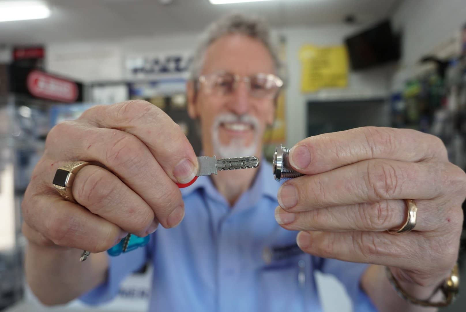 Man holding a key and lock cylinder in focus