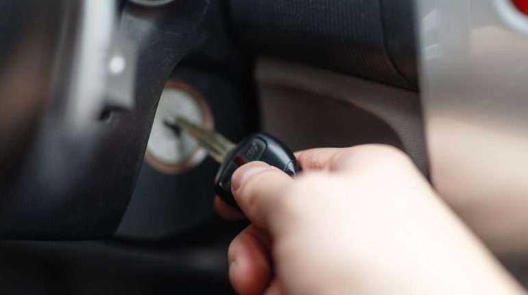 A hand inserting key into ignition.