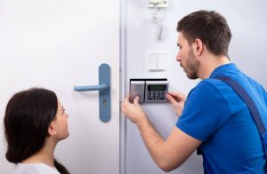 Locksmith installing home security system.