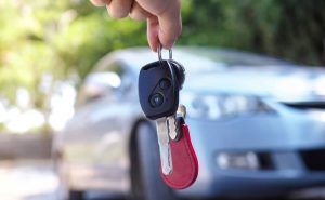 person locked out of vehicle hanging the spare car keys in front of car