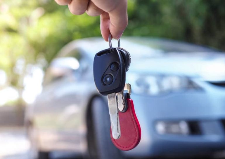 person locked out of vehicle hanging the spare car keys in front of car