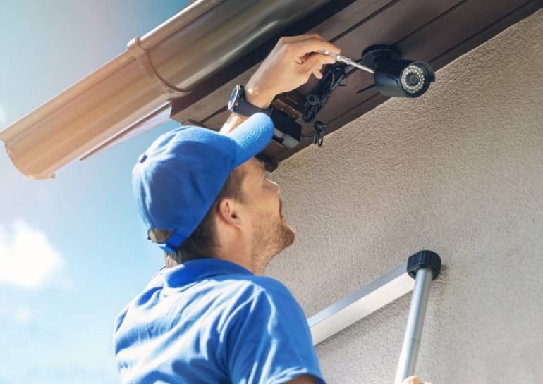 Technician installing security camera.