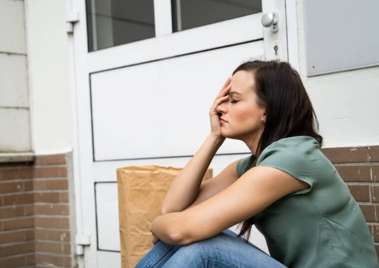 woman sitting down locked out of her house
