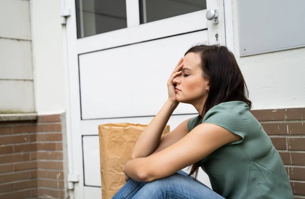 woman sitting down locked out of her house